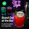 Alt-tag: *Vibrant red cocktail at Velvet Lounge with a custom edible drink topper reading “Cheers at Velvet Lounge,” garnished with mint, set against a stylish bar backdrop with neon “Sip in Style” sign and other colorful drinks blurred in the background.