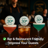 Three cocktails with 'Happy 30th Years' coasters on a bar counter, with a blurred bar setting in the background.