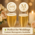 Two champagne flutes with personalized edible drink toppers, featuring gold monogram designs, displayed on an elegant wedding table with soft florals, candles, and warm fairy lights in the background.